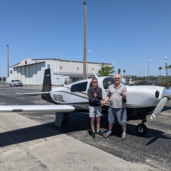Reece and Mike Elliott after solo with Mooney N618BL (thumbs up, handshake)